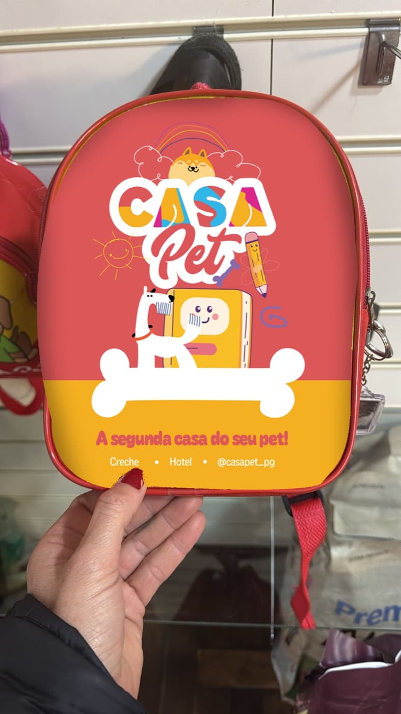 Mochila vermelha da Casa Pet com ilustração de cão e o mote a segunda casa do seu pet