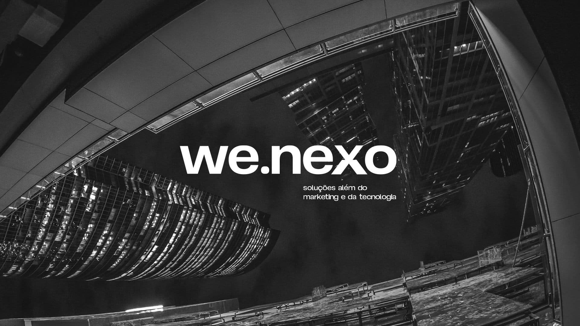 Wallpaper we.nexo com fotografia fish-eye de arquitetura industrial em preto e branco e tagline 'soluções além do marketing e da tecnologia'